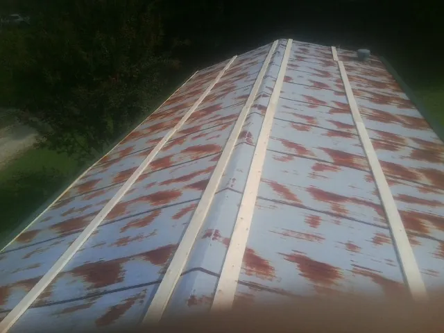 Rusted metal roof panels with new wood purlins before replacement — Storm Damage Roof Repair in Bunkerville by Roofing Brothers