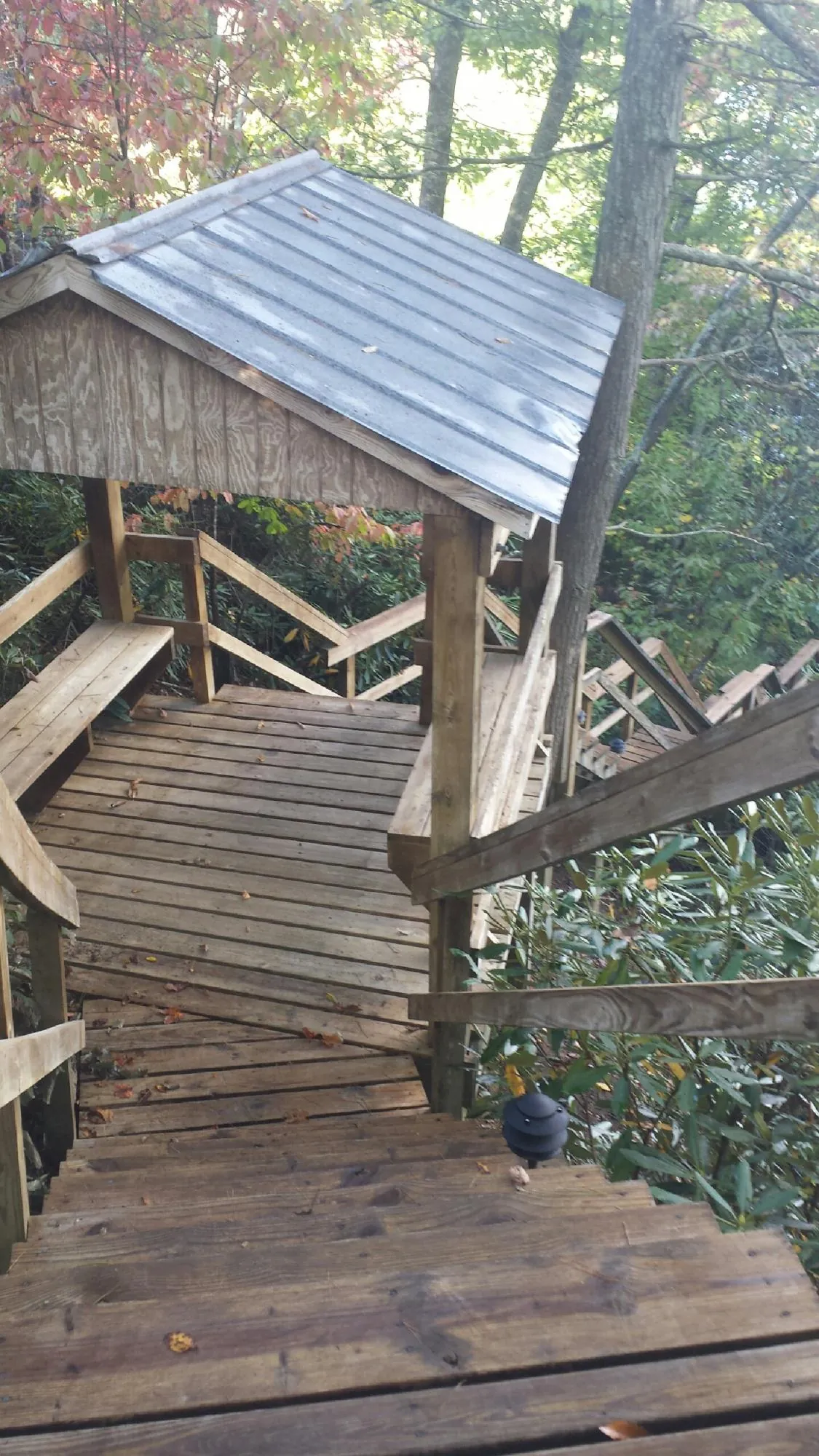 Metal roofed shelter over wooden steps on a wooded walkway — Skylight Repair & Installation work by our crew in Bunkerville